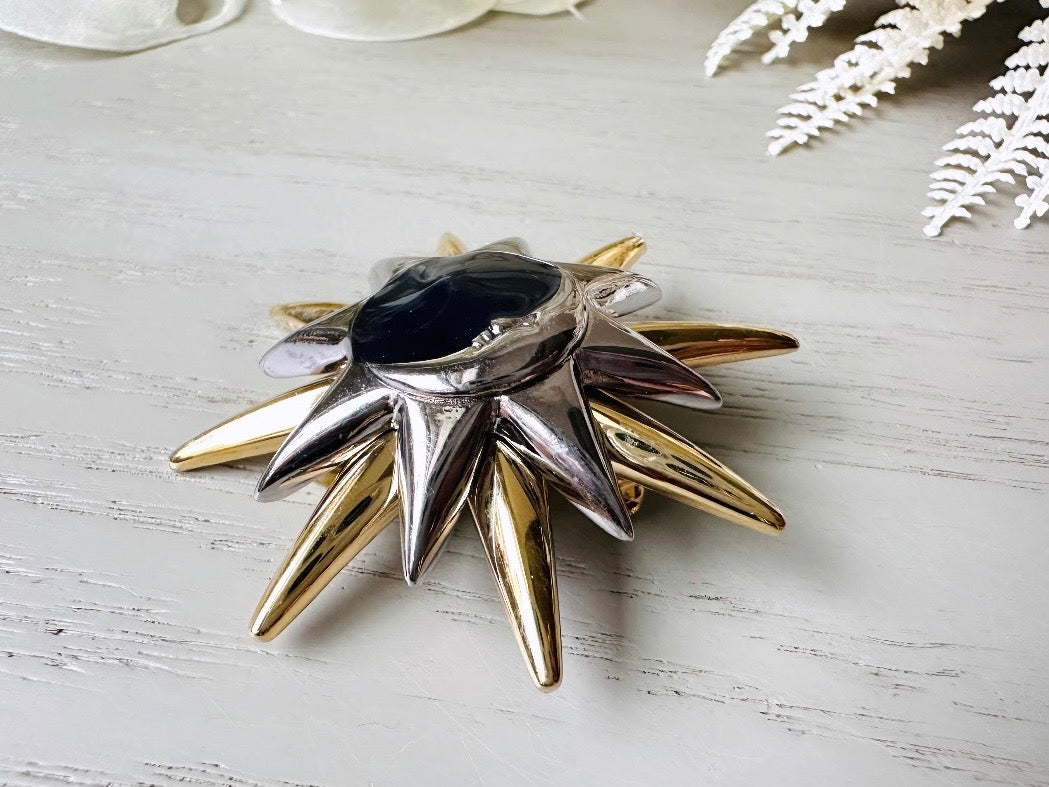 This is a vintage Liz Claiborne moon and starburst brooch from the 1980s. In excellent condition, this pin features a silver and gold starburst with a silver crescent moon on top of black circular enamel inlay. High quality designer signed brooch. No flaws to note, this vintage brooch has a fully working pin and lock, in great condition.