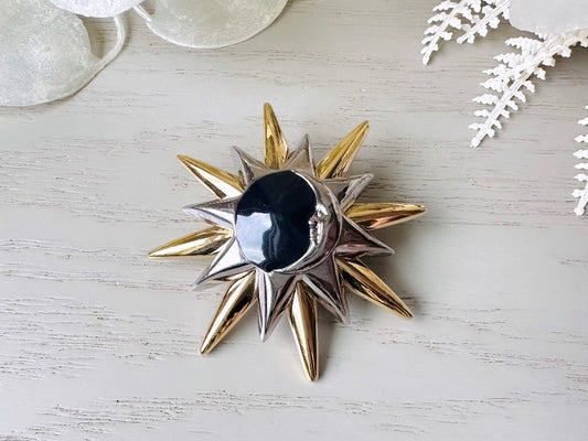 This is a vintage Liz Claiborne moon and starburst brooch from the 1980s. In excellent condition, this pin features a silver and gold starburst with a silver crescent moon on top of black circular enamel inlay. High quality designer signed brooch. No flaws to note, this vintage brooch has a fully working pin and lock, in great condition.