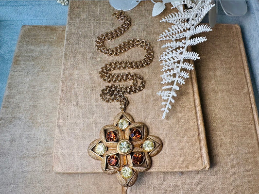 This 1970s vintage gold maltese cross pendant necklace is absolutely stunning! Featuring shimmering crystals in topaz and citrine set in a textured gold Etruscan pendant. This large bold vintage pendant is suspended from its original double link gold rolo chain, that fastens with a spring ring clasp. Signed SC from 1975. 