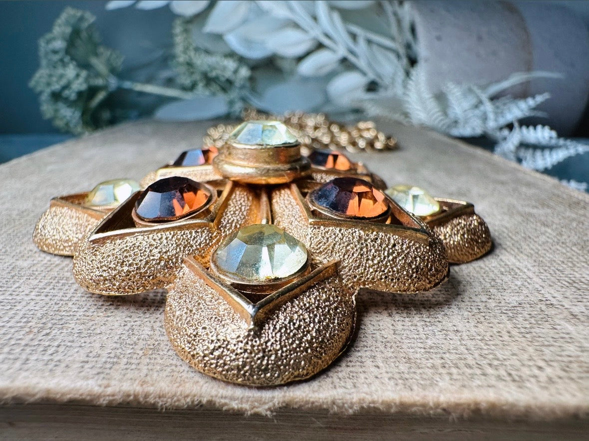 This 1970s vintage gold maltese cross pendant necklace is absolutely stunning! Featuring shimmering crystals in topaz and citrine set in a textured gold Etruscan pendant. This large bold vintage pendant is suspended from its original double link gold rolo chain, that fastens with a spring ring clasp. Signed SC from 1975. 