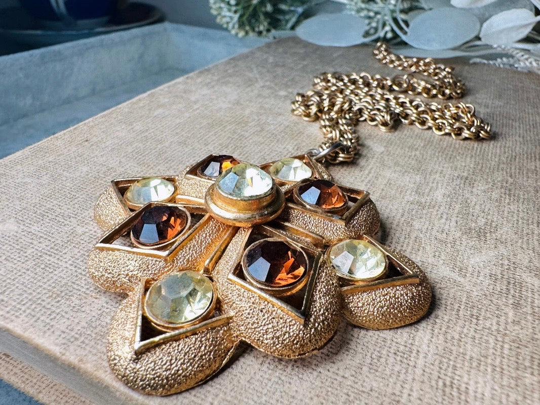 This 1970s vintage gold maltese cross pendant necklace is absolutely stunning! Featuring shimmering crystals in topaz and citrine set in a textured gold Etruscan pendant. This large bold vintage pendant is suspended from its original double link gold rolo chain, that fastens with a spring ring clasp. Signed SC from 1975. 