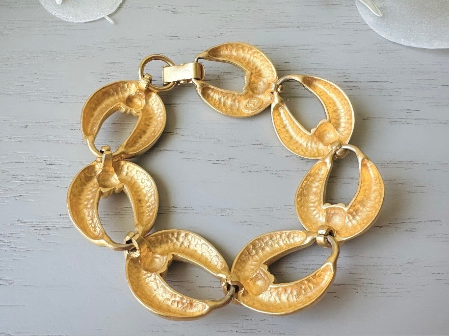 This is a matte gold chain link vintage bracelet by Premier Designs. The links are round and wide with textured ribbing in the center. The finish is a satin matte gold. Very popular style in the 1980s and modern.