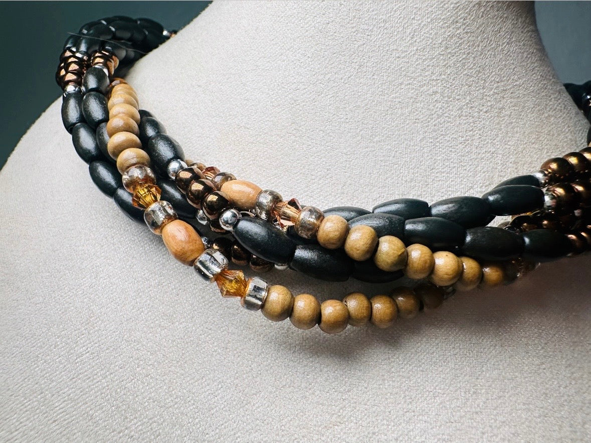 This vintage Napier necklace is a beautiful beaded twisted multistrand choker. Featuring six beaded strands in varying shapes and sizes composed of beads in wood, glass, acrylic, this bold necklace is a fabulous addition to your jewelry box. The beaded strands connect with a gold extension chain finished with a beautiful stamped Napier tag. 