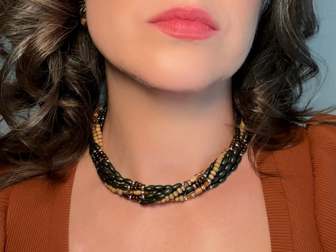 This vintage Napier necklace is a beautiful beaded twisted multistrand choker. Featuring six beaded strands in varying shapes and sizes composed of beads in wood, glass, acrylic, this bold necklace is a fabulous addition to your jewelry box. The beaded strands connect with a gold extension chain finished with a beautiful stamped Napier tag. 