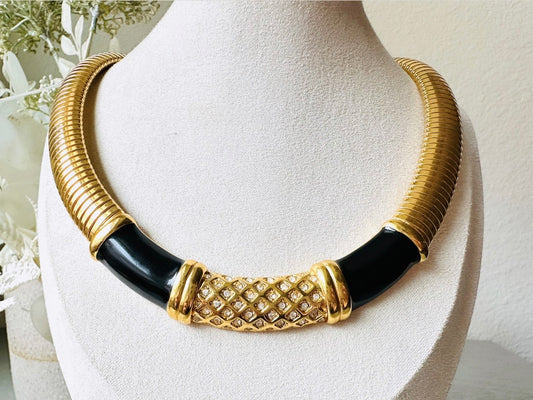 This vintage omega necklace is a stunning black and gold Monet designer vintage necklace. Featuring wide band snake chain and geometric segments of black enamel. This 1980s vintage rhinestone collar necklace has a fold over clasp and extender link. &nbsp;Excellent condition. This vintage designer necklace is high quality, weighty and well made. 