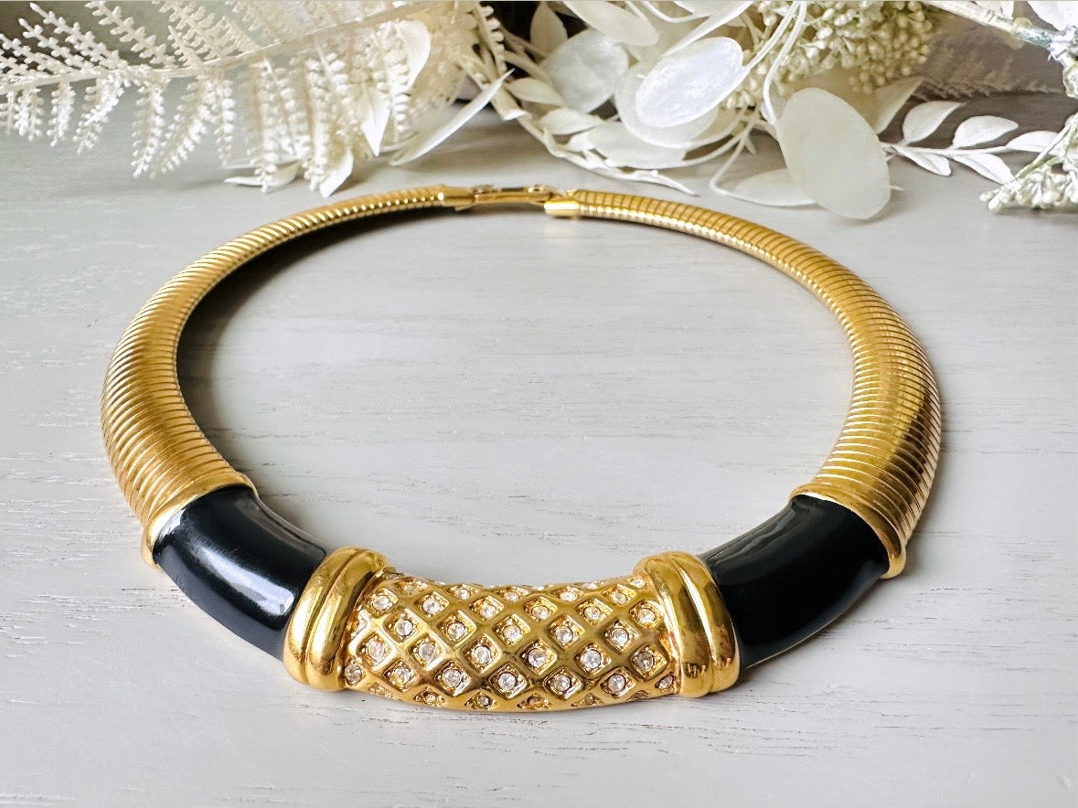 This vintage omega necklace is a stunning black and gold Monet designer vintage necklace. Featuring wide band snake chain and geometric segments of black enamel. This 1980s vintage rhinestone collar necklace has a fold over clasp and extender link. &nbsp;Excellent condition. This vintage designer necklace is high quality, weighty and well made. 