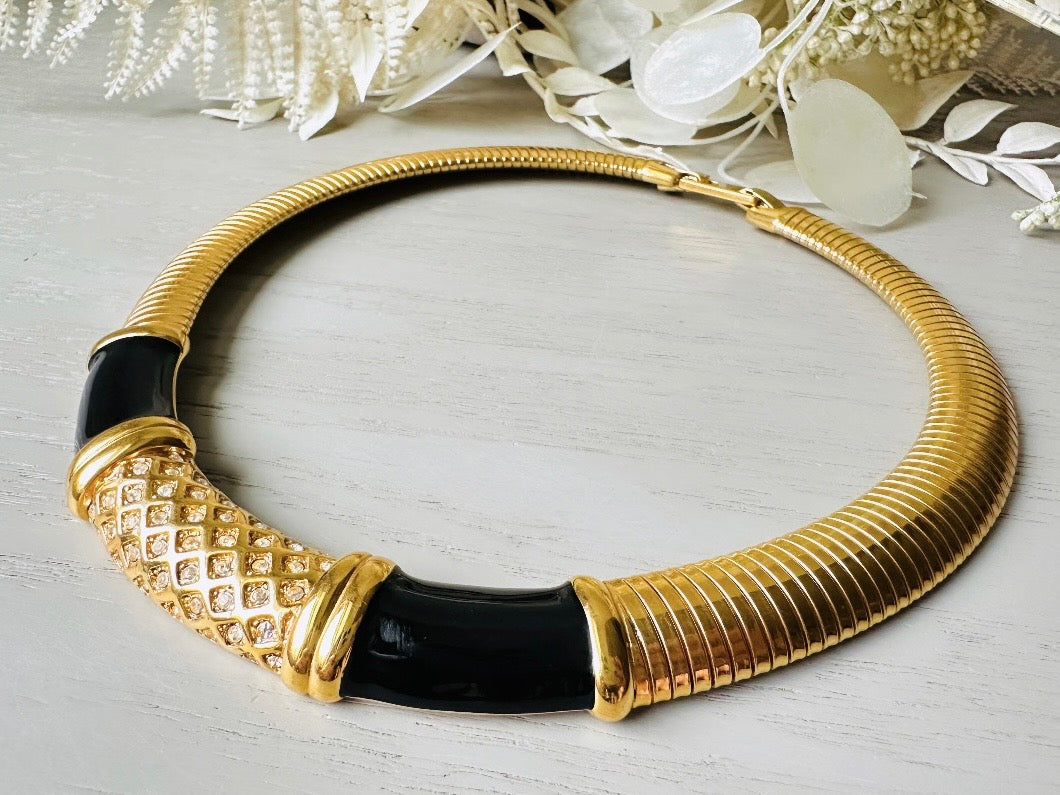 This vintage omega necklace is a stunning black and gold Monet designer vintage necklace. Featuring wide band snake chain and geometric segments of black enamel. This 1980s vintage rhinestone collar necklace has a fold over clasp and extender link. &nbsp;Excellent condition. This vintage designer necklace is high quality, weighty and well made. 