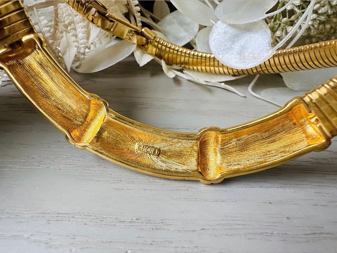 This vintage omega necklace is a stunning black and gold Monet designer vintage necklace. Featuring wide band snake chain and geometric segments of black enamel. This 1980s vintage rhinestone collar necklace has a fold over clasp and extender link. &nbsp;Excellent condition. This vintage designer necklace is high quality, weighty and well made. 