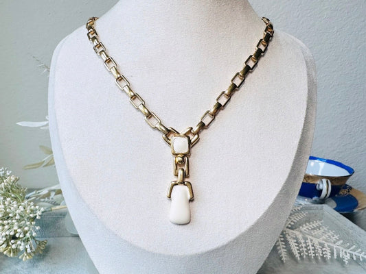 This vintage gold chain Y necklace by Monet is a rare find. Featuring flat link cable chain with a geometric drop pendant with cream enamel accents. This signed vintage necklace is from the 1970s at a peak time for Monet designs. This classic necklace is in excellent condition and just as classic today as it was when it debuted. Adjustable length with a hook closure.&nbsp;
