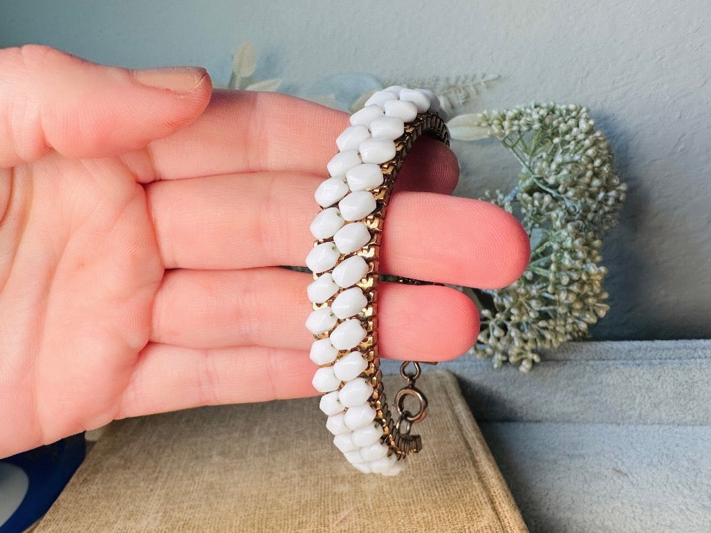 This beautiful white and gold 1960s vintage bracelet is so very pretty. Featuring triple strands of gold mesh chain with two strands of faceted milk glass crystals woven into the design. A simple spring ring closure brings this bracelet together. Easy to wear for everyday or would make a gorgeous bridal piece. A classic 1960s piece- in great vintage condition- &nbsp;please see all pics.

Dimensions: approximately 7.5" long, 0.5" wide.