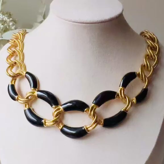 This is a vintage 1980s Napier black and gold chain necklace. It had textured double link gold chain links in rich brushed gold that interlocks with wider chain links with glossy black enamel. Signed designer vintage piece. Modelled for size reference the length is on the collar. video