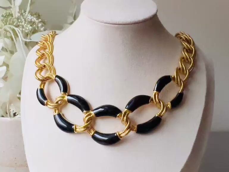 This is a vintage 1980s Napier black and gold chain necklace. It had textured double link gold chain links in rich brushed gold that interlocks with wider chain links with glossy black enamel. Signed designer vintage piece. Modelled for size reference the length is on the collar. video