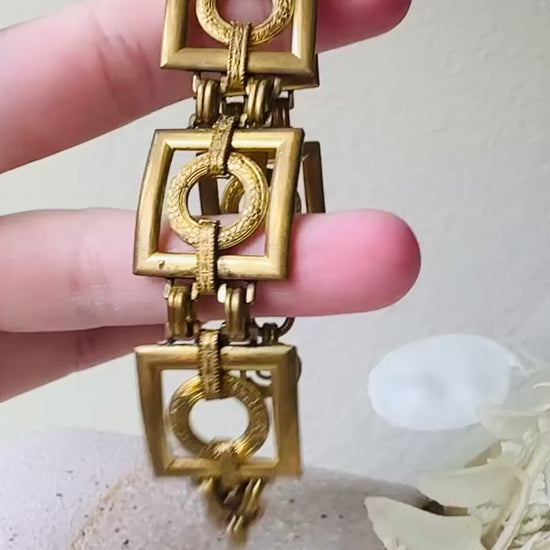 This is a vintage square link bracelet composed of antique gold geometric links. Featuring five structured squares with a floral embossed circle ring inside each one. This bold 1970s vintage chain bracelet is so unique; the circle inside of square and contrast of the bold shape with the royal floral motif is so interesting. It is 7 inches long in great vintage condition. Video