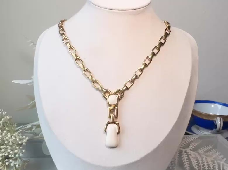 This vintage gold chain Y necklace by Monet is a rare find. Featuring flat link cable chain with a geometric drop pendant with cream enamel accents. This signed vintage necklace is from the 1970s at a peak time for Monet designs. This classic necklace is in excellent condition and just as classic today as it was when it debuted. Adjustable length with a hook closure.  video