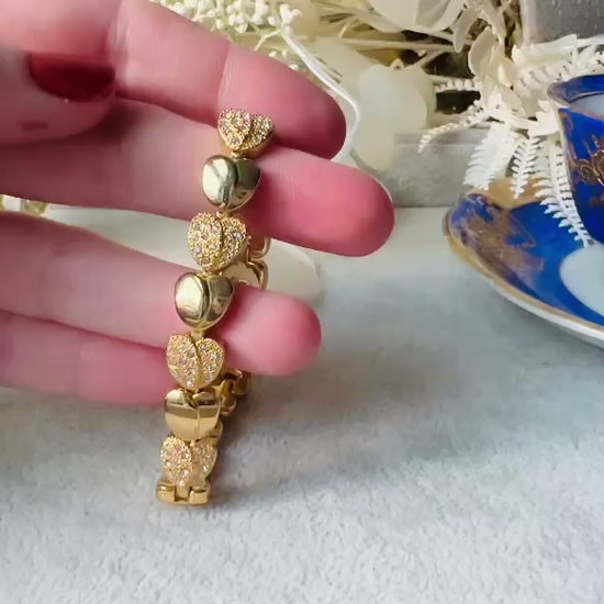 This sparkling rhinestone and gold heart bracelet is so darling. Featuring smooth gold hearts alternating with pave set rhinestone heart links. A lovely classic little bracelet. video