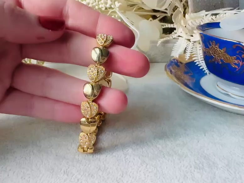 This sparkling rhinestone and gold heart bracelet is so darling. Featuring smooth gold hearts alternating with pave set rhinestone heart links. A lovely classic little bracelet. video