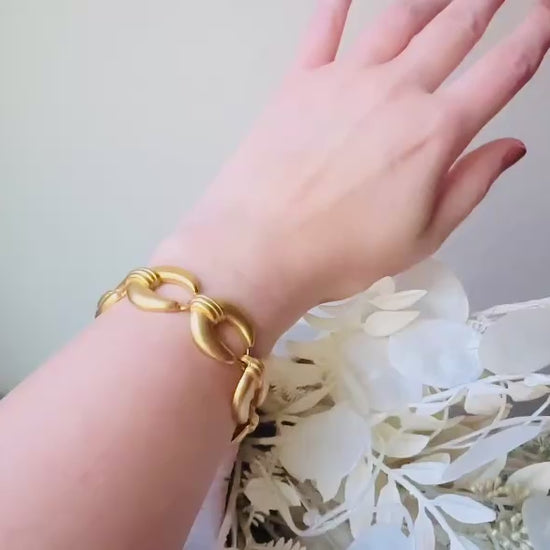 This is a matte gold chain link vintage bracelet by Premier Designs. The links are round and wide with textured ribbing in the center. The finish is a satin matte gold. Very popular style in the 1980s and modern. Video of the bracelet worn for size reference.
