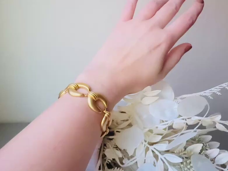 This is a matte gold chain link vintage bracelet by Premier Designs. The links are round and wide with textured ribbing in the center. The finish is a satin matte gold. Very popular style in the 1980s and modern. Video of the bracelet worn for size reference.