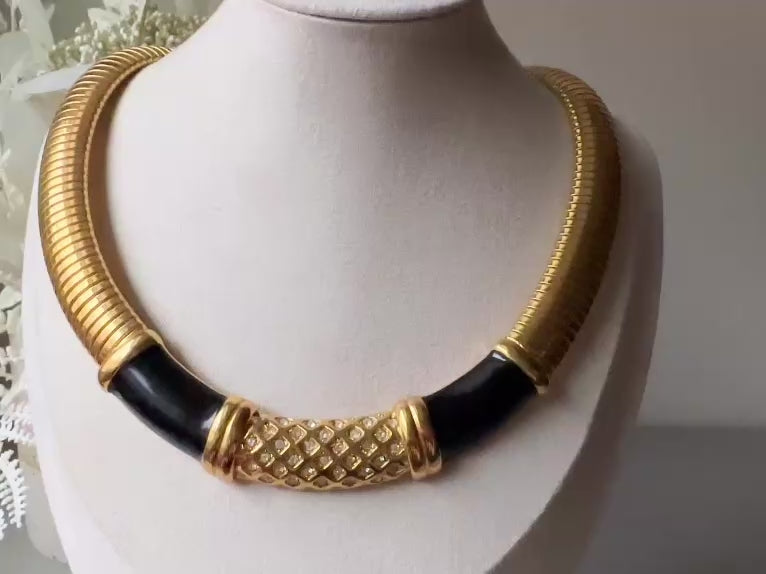 This vintage omega necklace is a stunning black and gold Monet designer vintage necklace. Featuring wide band snake chain and geometric segments of black enamel. This 1980s vintage rhinestone collar necklace has a fold over clasp and extender link. &nbsp;Excellent condition. This vintage designer necklace is high quality, weighty and well made. Video.