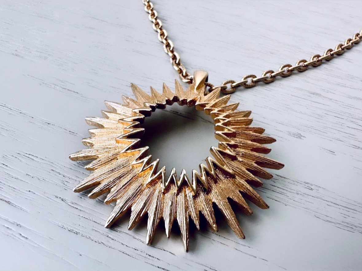 Close up of vintage gold starburst pendant necklace from Piggle and Pop